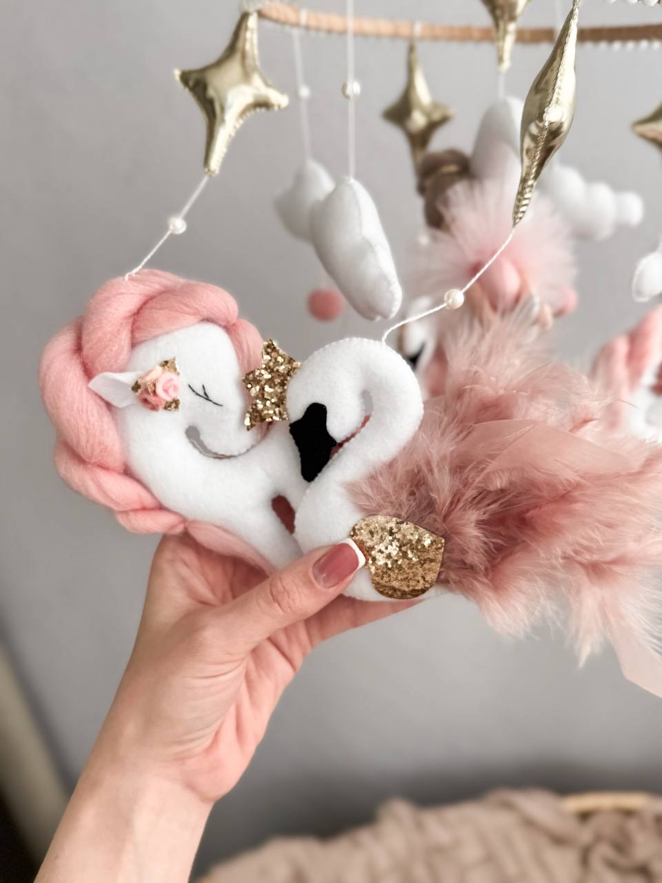 Dettaglio giostrina culla feltro unicorno cigno bianco rosa cipria oro glitter piume stelle carillon neonata