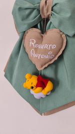 Primo piano di Winnie the Pooh in feltro su nuvola e cuore tortora con doppio nome ricamato per fiocco nascita bimbo.