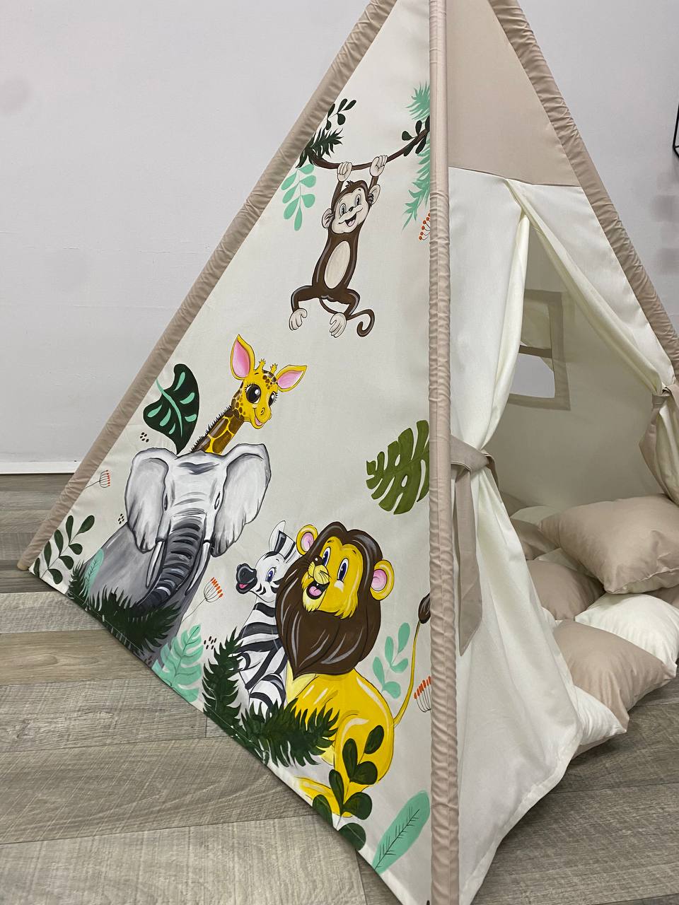 Tenda da gioco a forma di teepee per bambini, tessuto beige con illustrazioni dipinte a mano di animali della savana come leoni, elefanti, giraffe e zebre