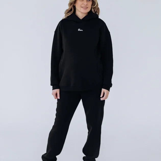 Retro della felpa premaman nera Warm&Cosy a figura intera, taglio lungo con cappuccio