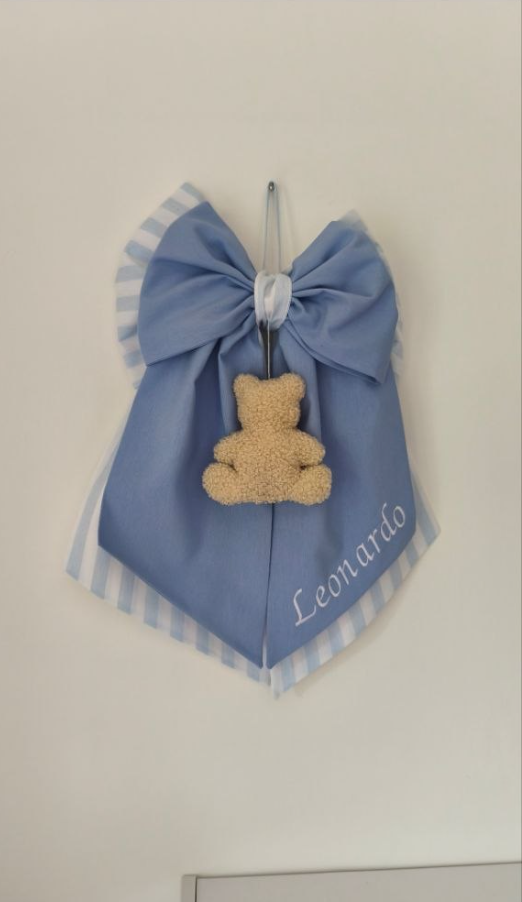 Fiocco nascita azzurro cielo con dettagli a righe bianche e orsetto pendente in soffice bouclé color panna