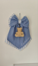 Fiocco nascita azzurro cielo con dettagli a righe bianche e orsetto pendente in soffice bouclé color panna
