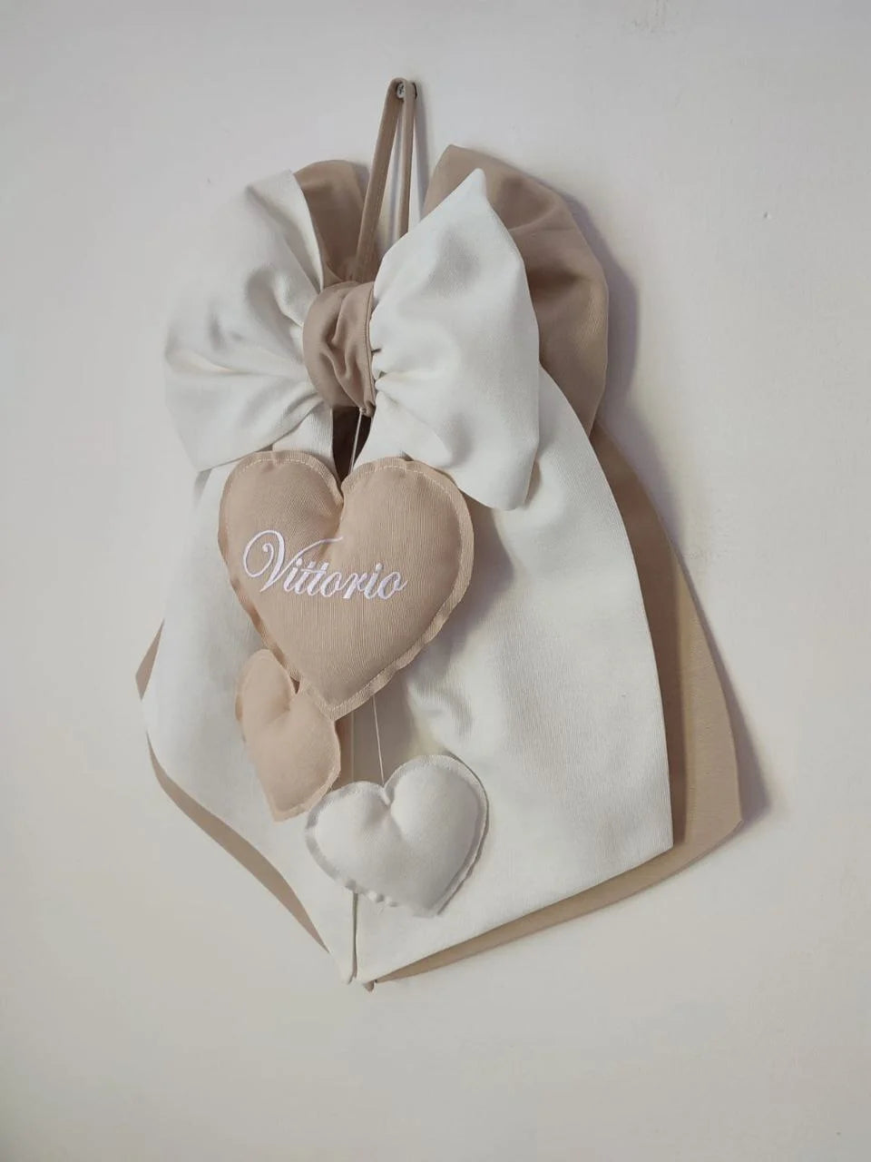 Fiocco nascita beige e bianco personalizzato con nome ricamato in bianco su cuore imbottito pendente
