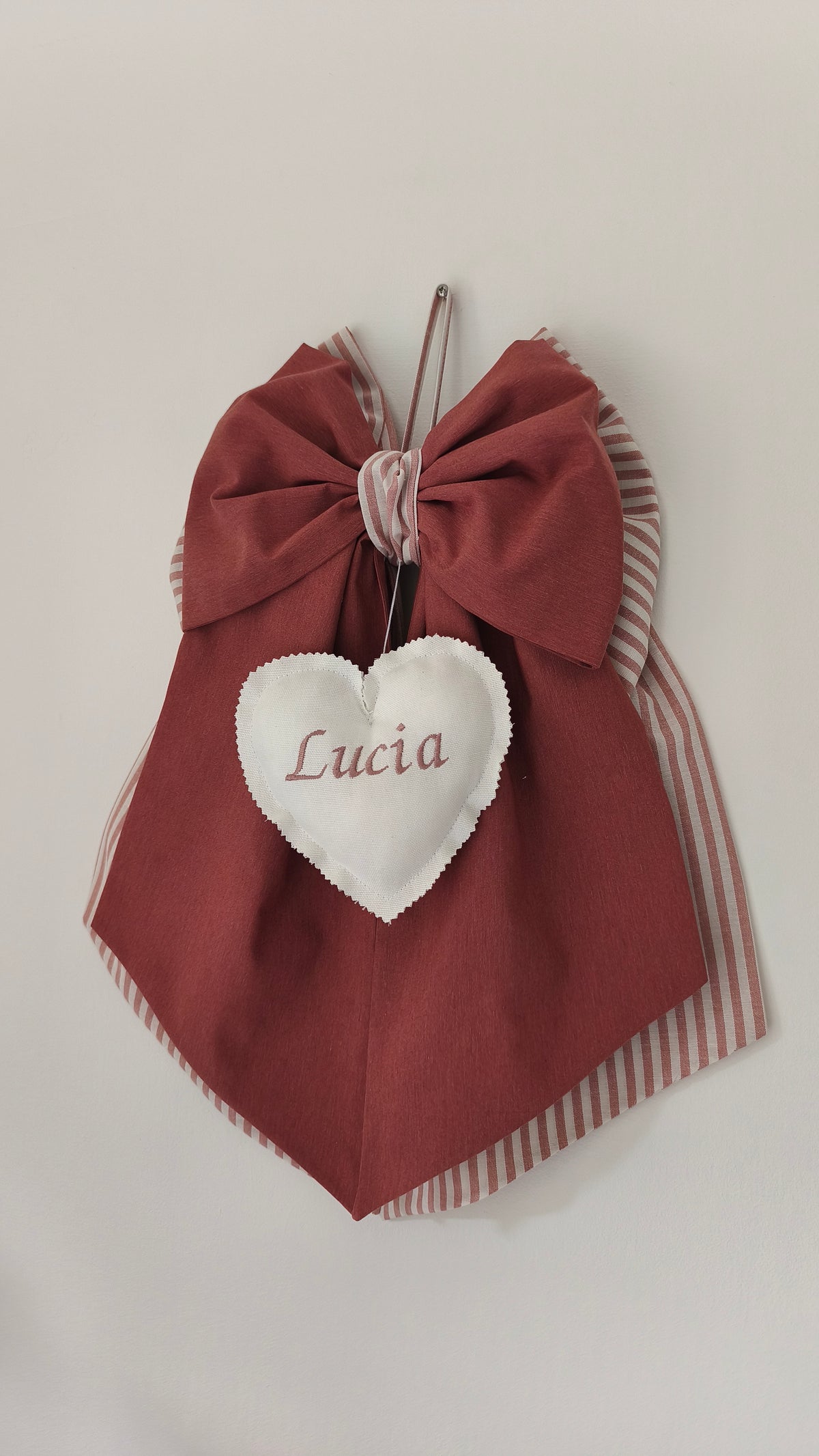 Fiocco nascita rosso mattone e beige a righe con cuore bianco centrale ricamato personalizzabile in tessuto.