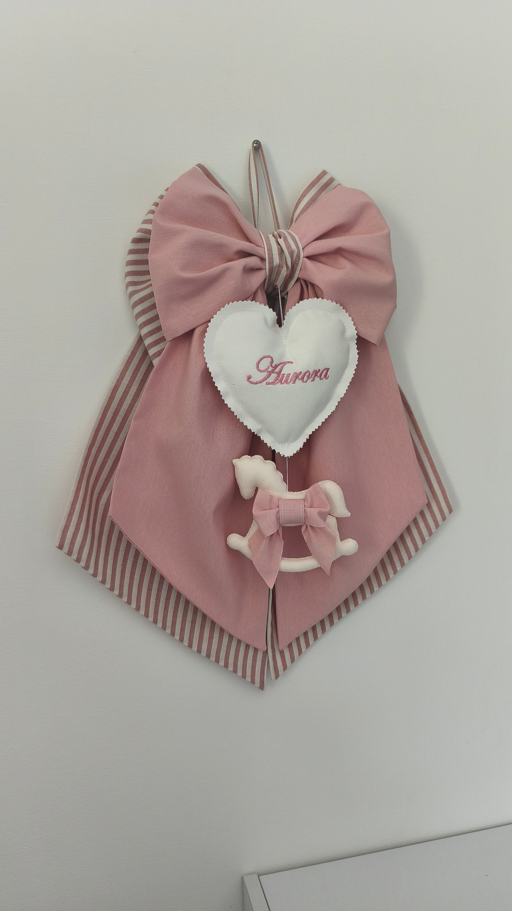 Fiocco nascita bimba in cotone rosa antico a righe con cuore bianco, nome ricamato e cavalluccio a dondolo con fiocchetto, fatto a mano