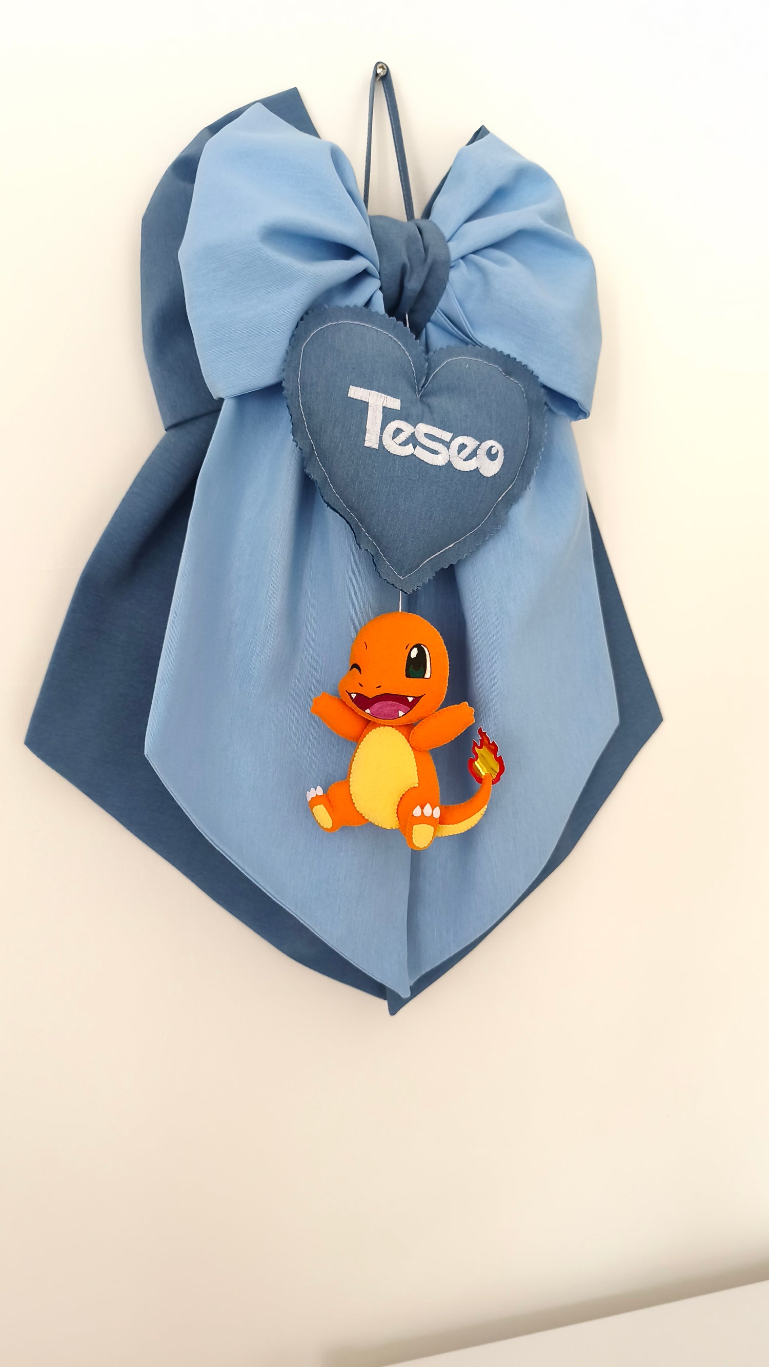 Fiocco nascita bimbo azzurro e blu con Charmander in feltro cucito a mano, cuore centrale personalizzabile con nome ricamato, regalo nascita artigianale a tema Pokémon.