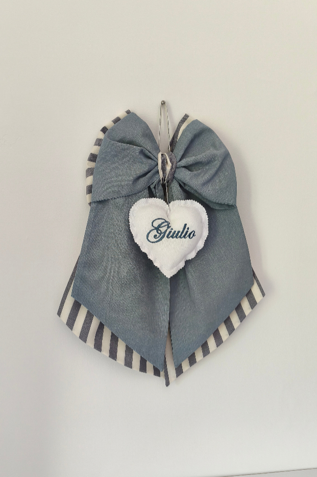 Fiocco nascita grigio e beige a righe con cuore bianco centrale ricamato personalizzabile appeso alla parete.