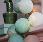 Ghirlanda luminosa palline cotone menta e tortora appesa a mensola, effetto glitter