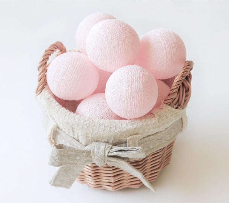 Palline di cotone luminose rosa in cestino vimini con fiocco, ghirlanda per cameretta