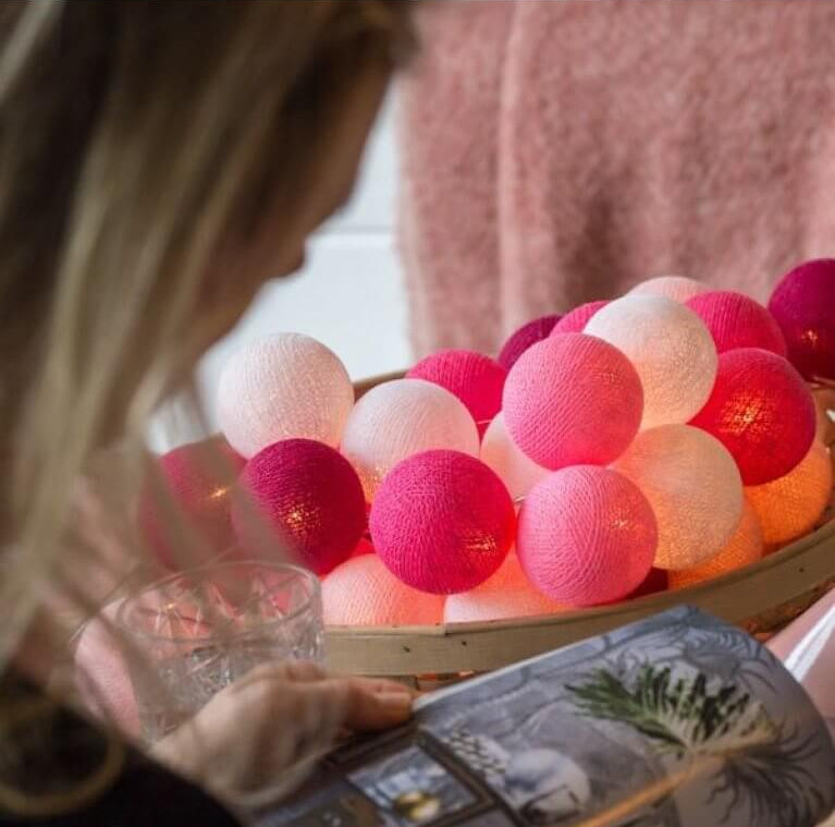 Palline luminose LED cotone rosa e fucsia accese in cesto vimini, ghirlanda cameretta