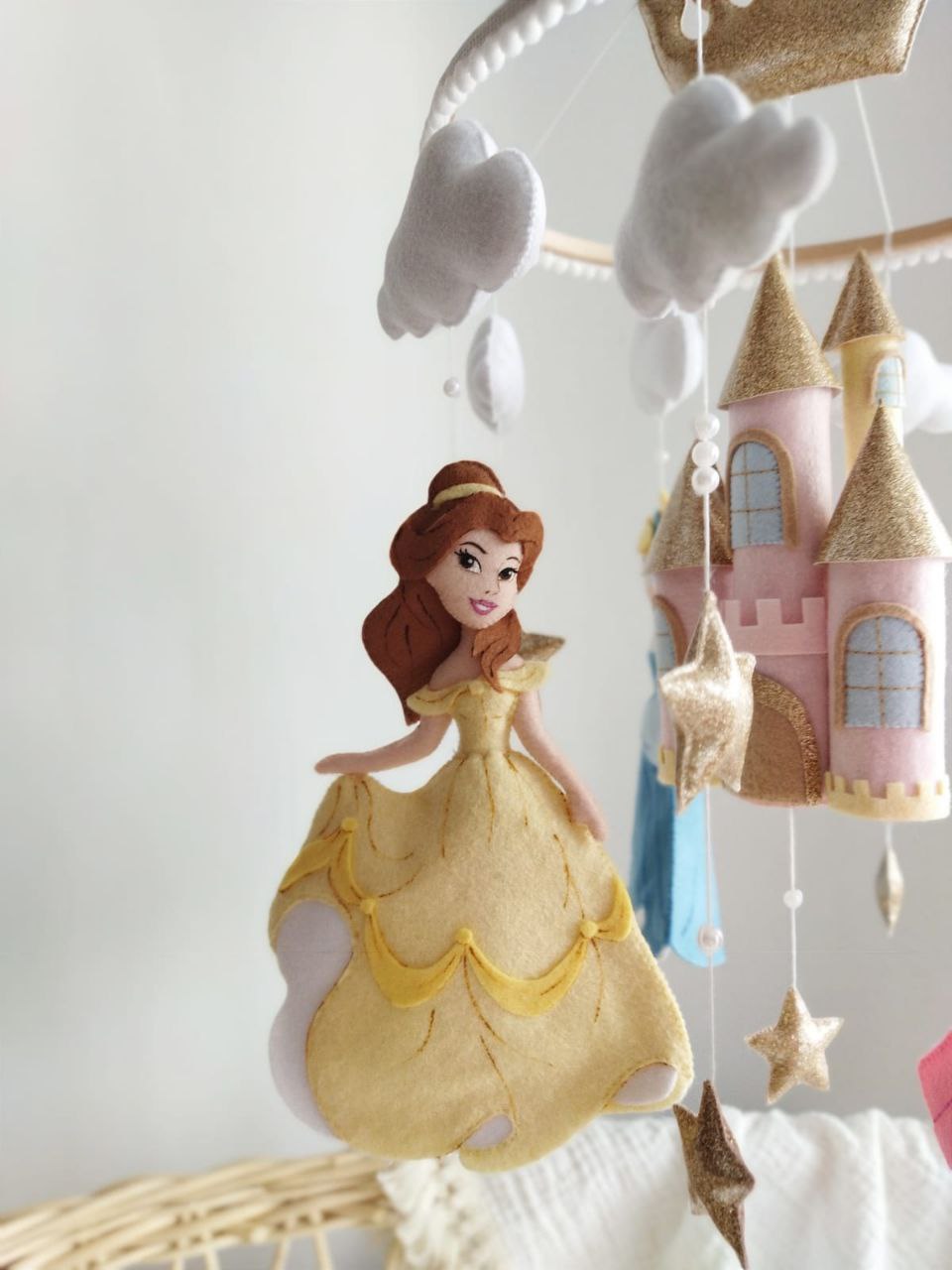 Dettaglio giostrina culla con principessa Belle giallo pastello, castello rosa antico e stelle in feltro oro glitter