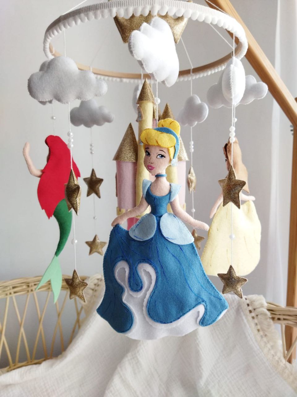 Dettaglio giostrina culla con Cenerentola in azzurro polvere, sirenetta Ariel rosso fuoco e stelle in feltro oro glitter