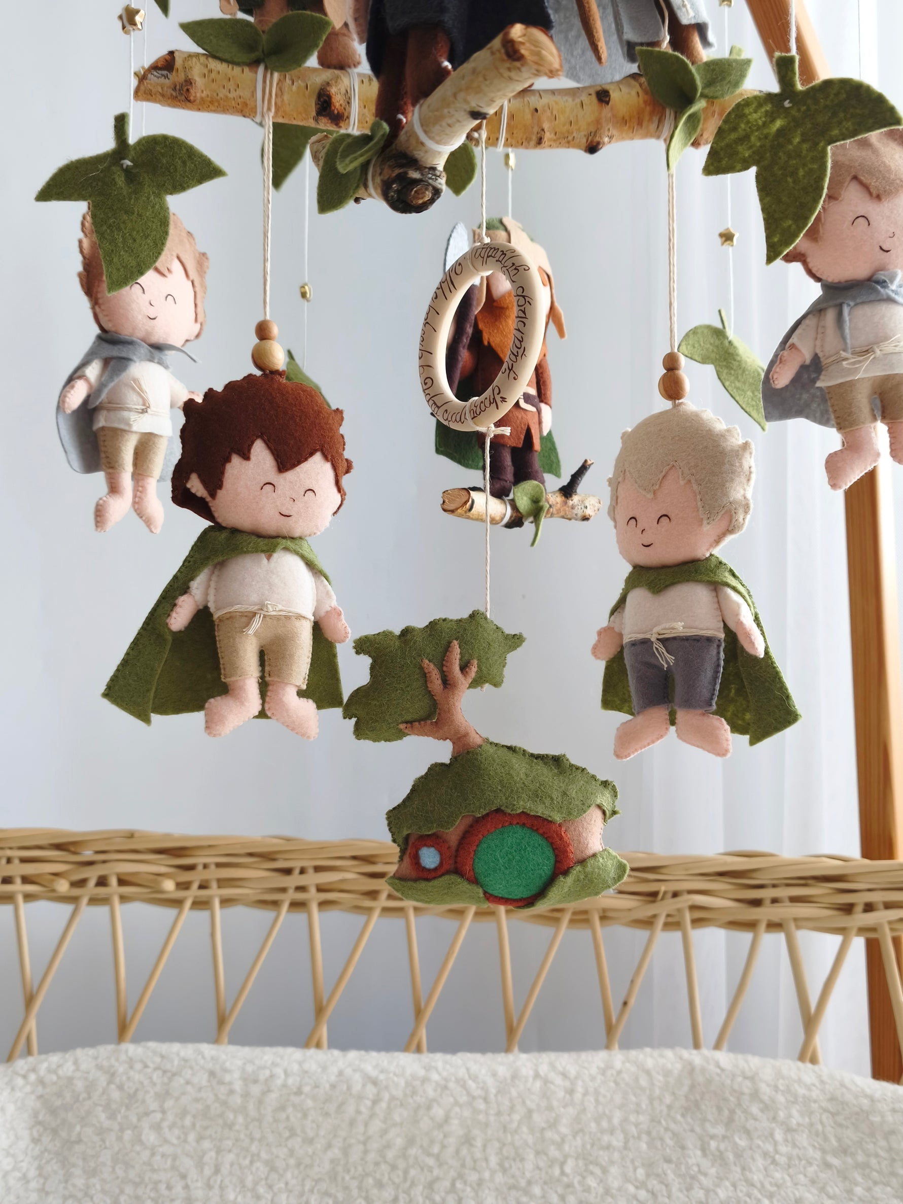 Dettaglio giostrina culla con Hobbit in feltro, Frodo, Sam e casa di Bilbo fatti a mano per cameretta neonato fantasy.