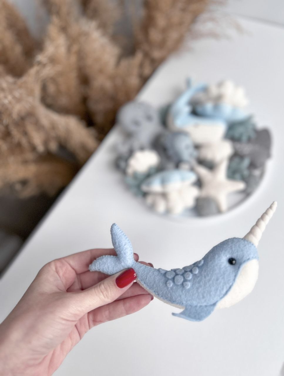 Narvalo in feltro azzurro polvere con corno crema cucito a mano, dettaglio giostrina culla mondo marino azzurro e grigio