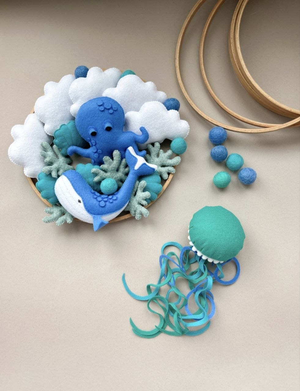 Personaggi in feltro della giostrina mondo marino blu: polpo, balena, medusa, nuvole, coralli salvia e cerchi in legno