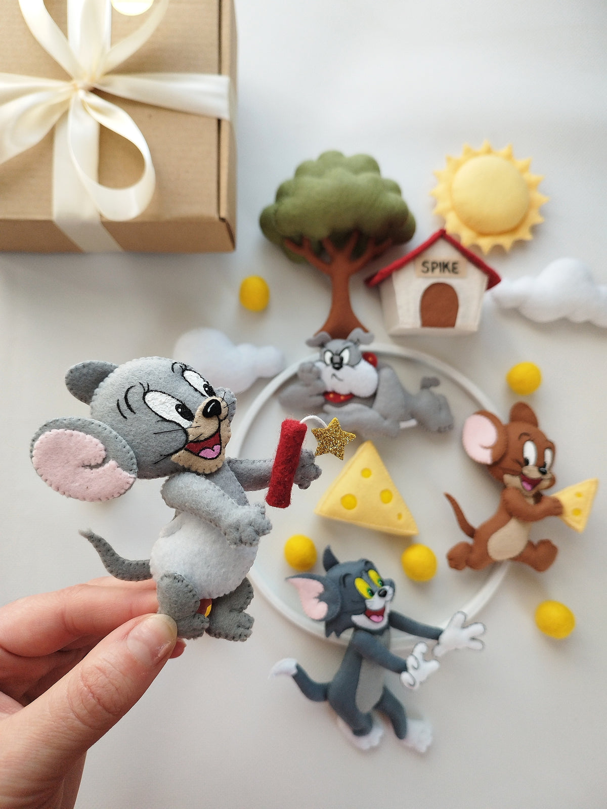 Dettaglio giostrina culla Tom e Jerry con topo Tuffy grigio chiaro, candelotto rosso e stella oro, regalo nascita neonato