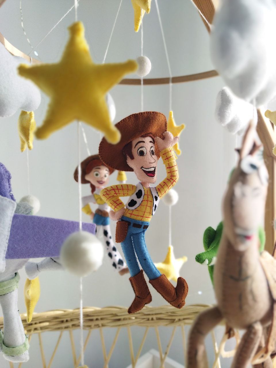 Dettaglio giostrina culla Toy Story con sceriffo Woody e Jessie in feltro fatti a mano e stella alpina, regalo nascita