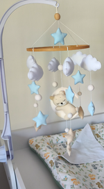 Giostrina neonato in feltro con orsetto dormiente, nuvole, stelle e pon pon nei toni azzurro e beige