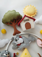 Giostrina musicale Tom e Jerry con cuccia bianca e rossa, albero verde oliva e sole giallo pastello, per lettino neonati
