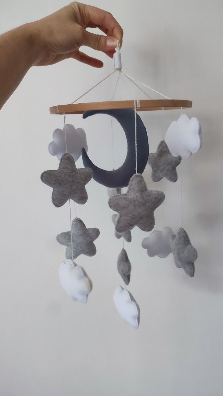 Lune e stelline in tessuto grigio della giostrina musicale per lettino