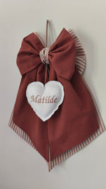 Fiocco nascita artigianale color mattone e beige a righe con cuore bianco imbottito e nome ricamato.