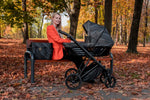 Passeggino Kunert Black Style navicella nera fantasia con borsa mamma seduta in parco foglie autunno