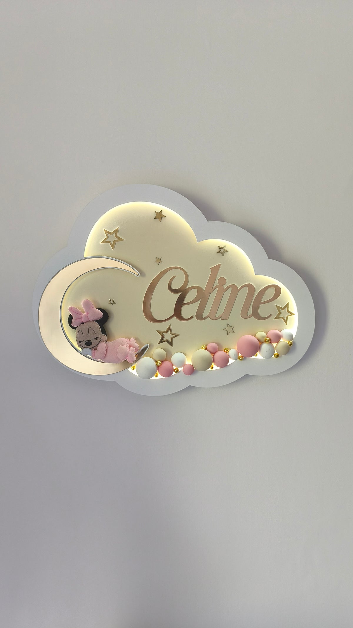 Luce notturna led a forma di nuvola con Minnie che dorme sulla luna, stelline oro e sfere decorative rosa.