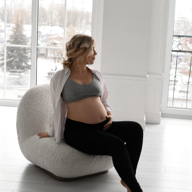 Leggings premaman neri in cotone elasticizzato indossati da seduta, comodi in gravidanza