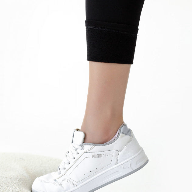 Dettaglio caviglia dei leggings premaman imbottiti neri indossati con sneakers