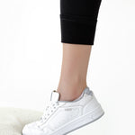 Dettaglio caviglia dei leggings premaman imbottiti neri indossati con sneakers
