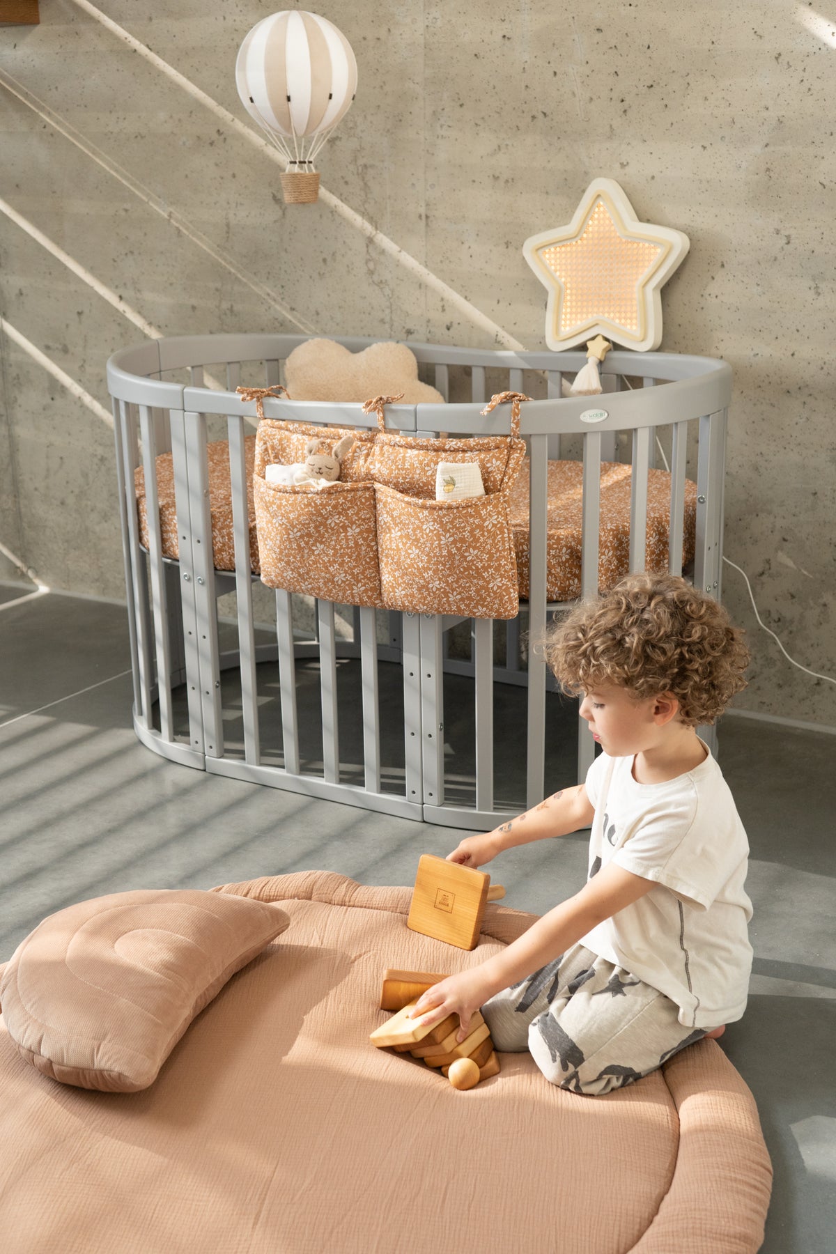 Lettino ovale grigio 7in1 materassino e con organizer floreale in cameretta moderna 
