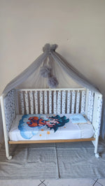 Lettino neonato con paracolpi americani a stelle grigie su fondo bianco, baldacchino in tulle grigio con pompon, cameretta bambino moderna