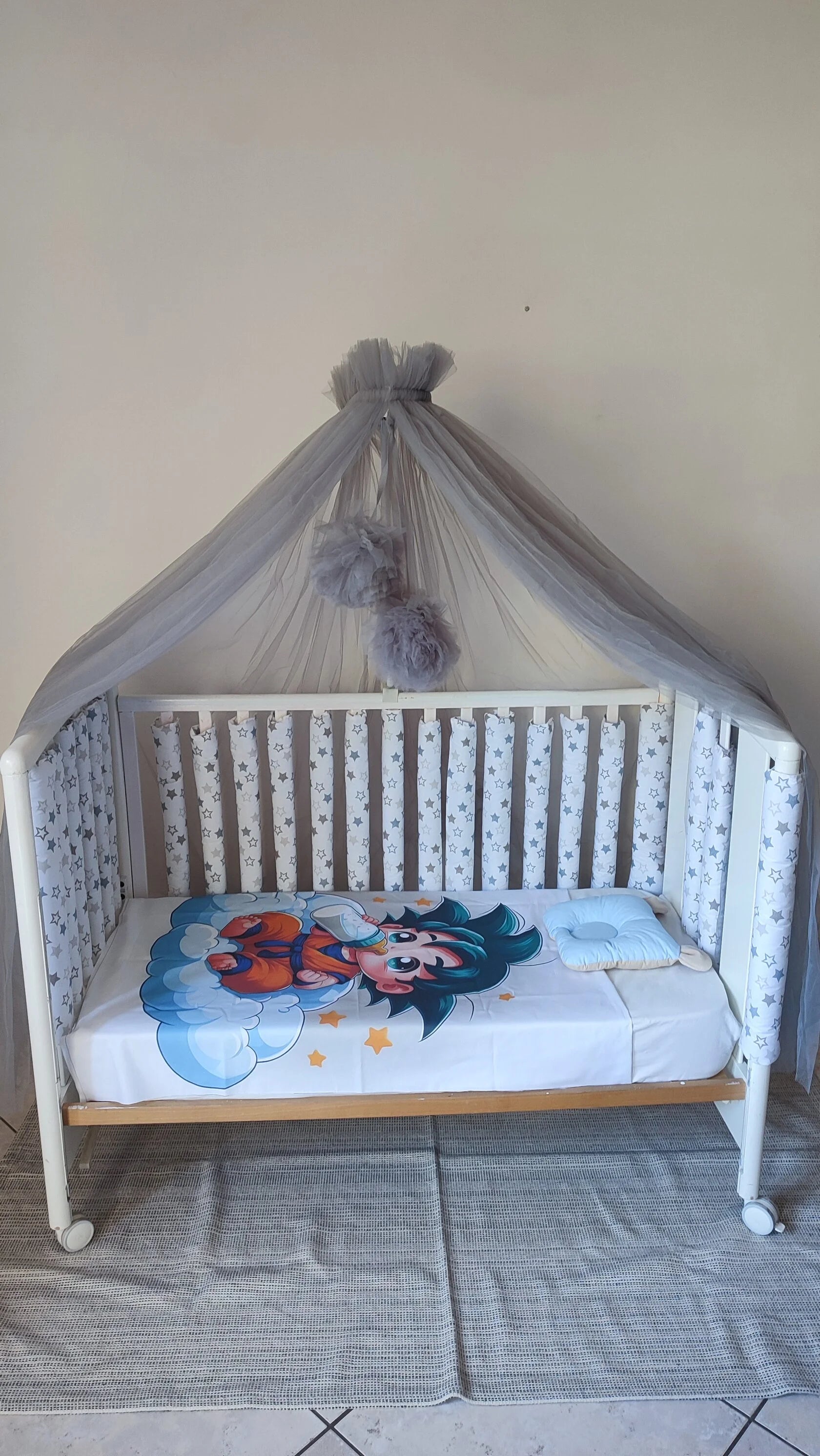 Lettino neonato con paracolpi americani a stelle grigie su fondo bianco, baldacchino in tulle grigio con pompon, cameretta bambino moderna