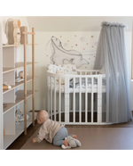 Culla ovale bianca 7in1 in camera neonato stile scandinavo con baldacchino in tulle grigio