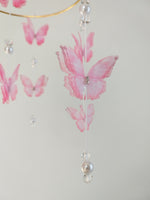Dettaglio farfalla organza rosa cipria con strass centrale perle bianche e cristalli pendenti mobile culla