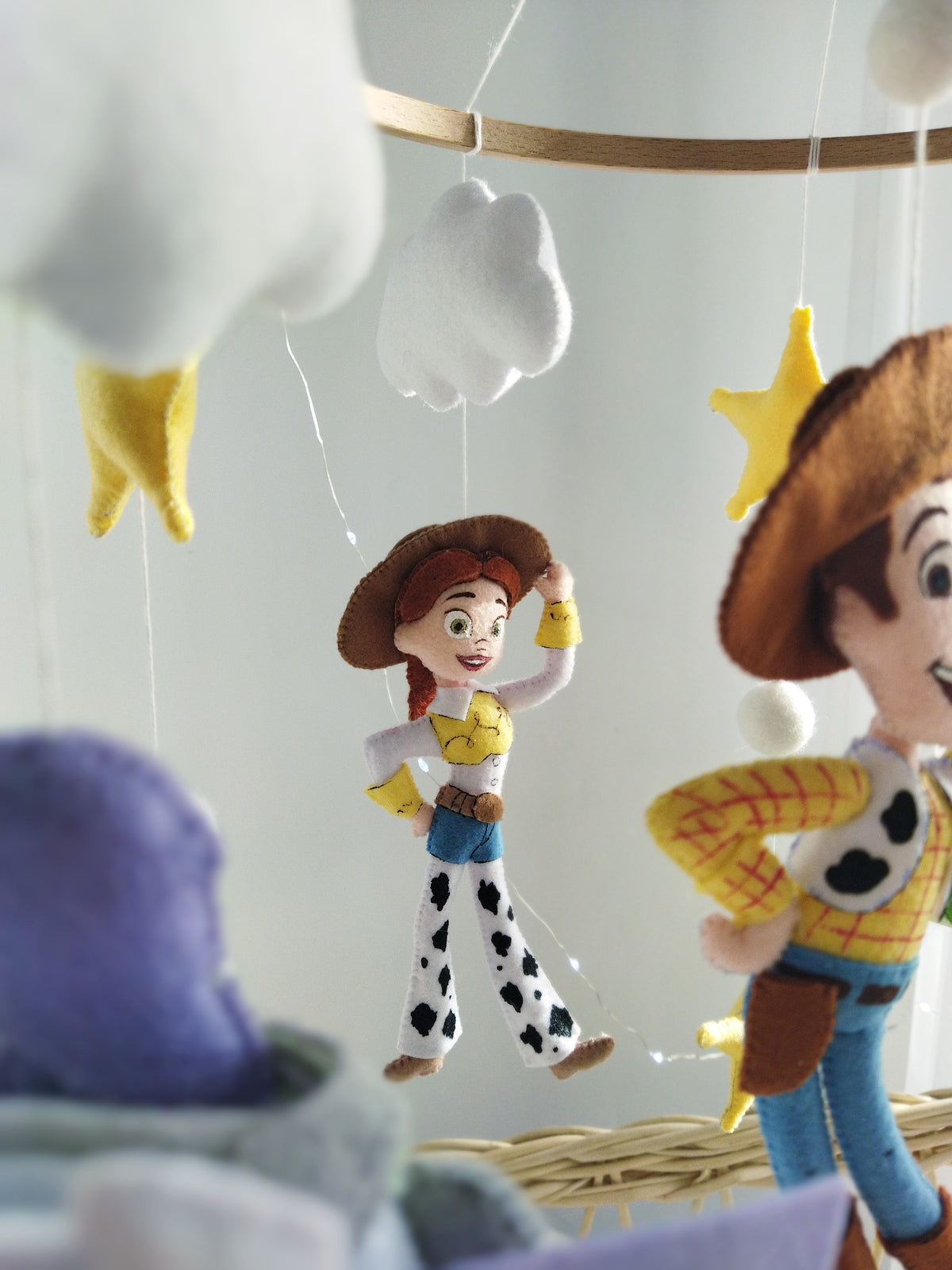Dettaglio mobile musicale culla Toy Story con bambolina Jessie in feltro fatta a mano e stelle, idea regalo nascita neonati