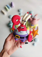 Dettaglio Mr. Krabs in feltro cucito a mano tenuto in mano per giostrina musicale neonato