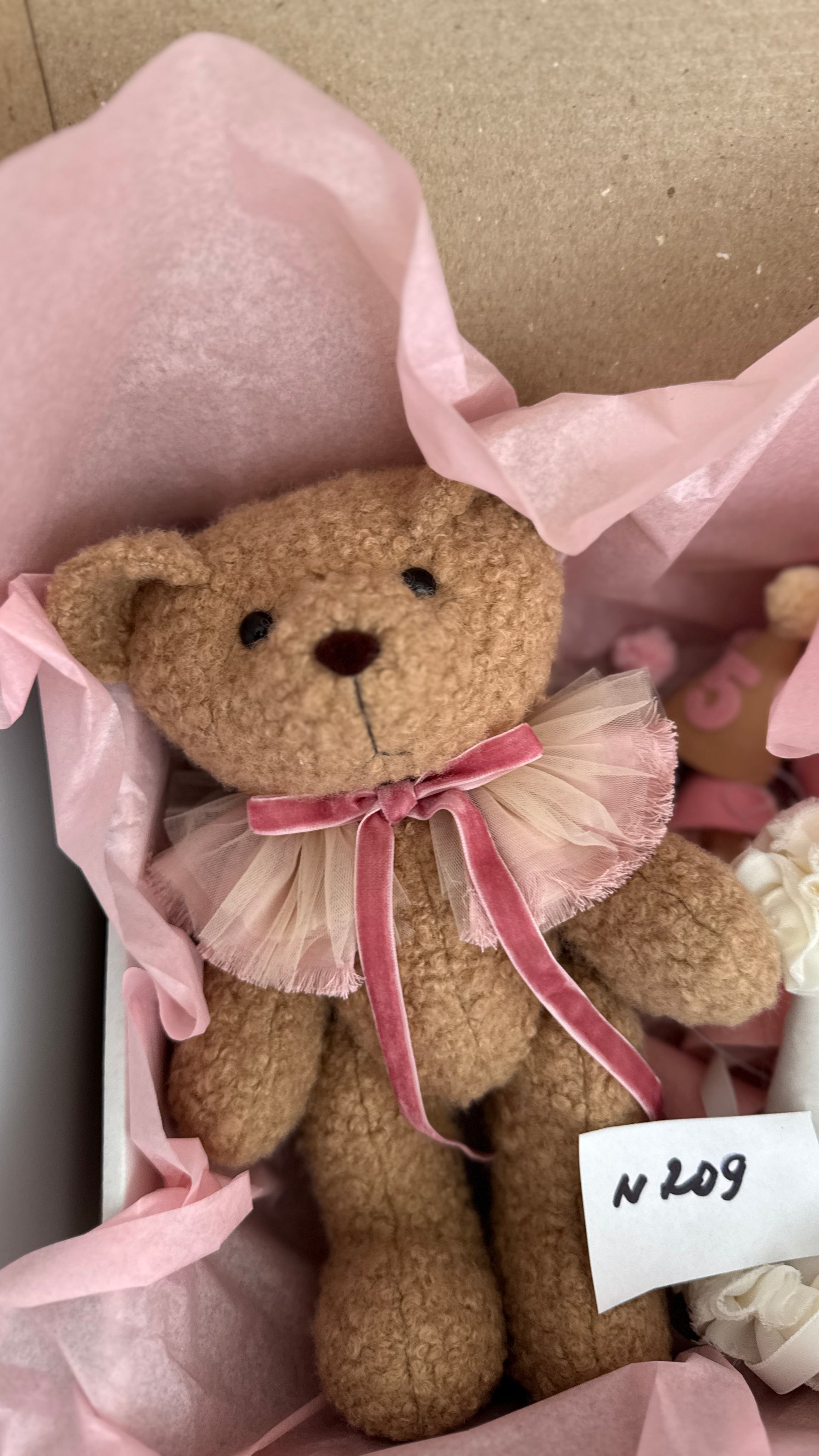 Orsetto di peluche artigianale in una confezione regalo con carta velina rosa per neonati