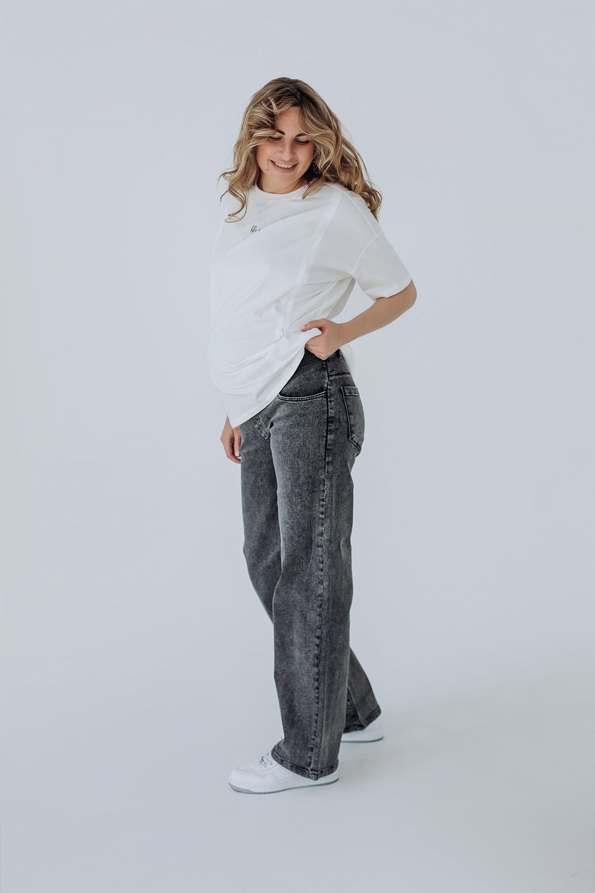Outfit premaman: t-shirt oversize bianca e jeans grigi a gamba dritta, look casual comodo