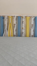Paracolpi americani montati su lettino neonato, vista frontale completa, fantasia orsetti acquerello con tinte unite giallo e celeste