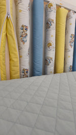 Dettaglio paracolpi americani con zip, cotone fantasia orsetti nuvole e sole in stile acquerello, tinte unite giallo e celeste, protezione lettino neonato