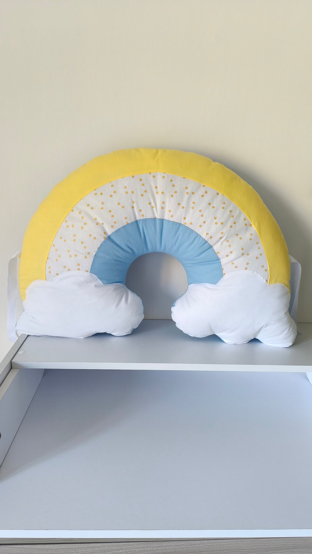 Cuscino decorativo arcobaleno con laccetti per sbarre lettino, perfetto come accessorio d'arredo per la cameretta.
