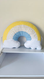 Cuscino decorativo arcobaleno con laccetti per sbarre lettino, perfetto come accessorio d'arredo per la cameretta.