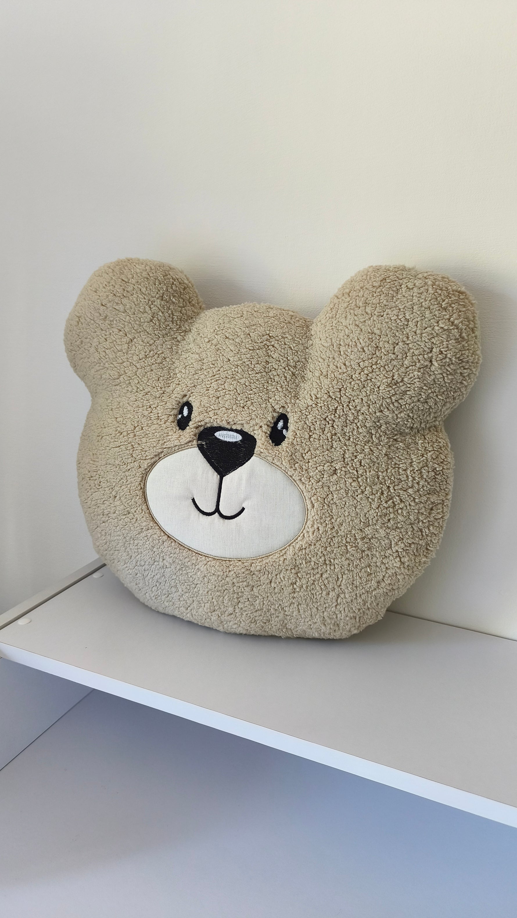 Cuscino a forma di orso color sabbia effetto peluche, ideale come arredo neutro per la cameretta dei bambini.