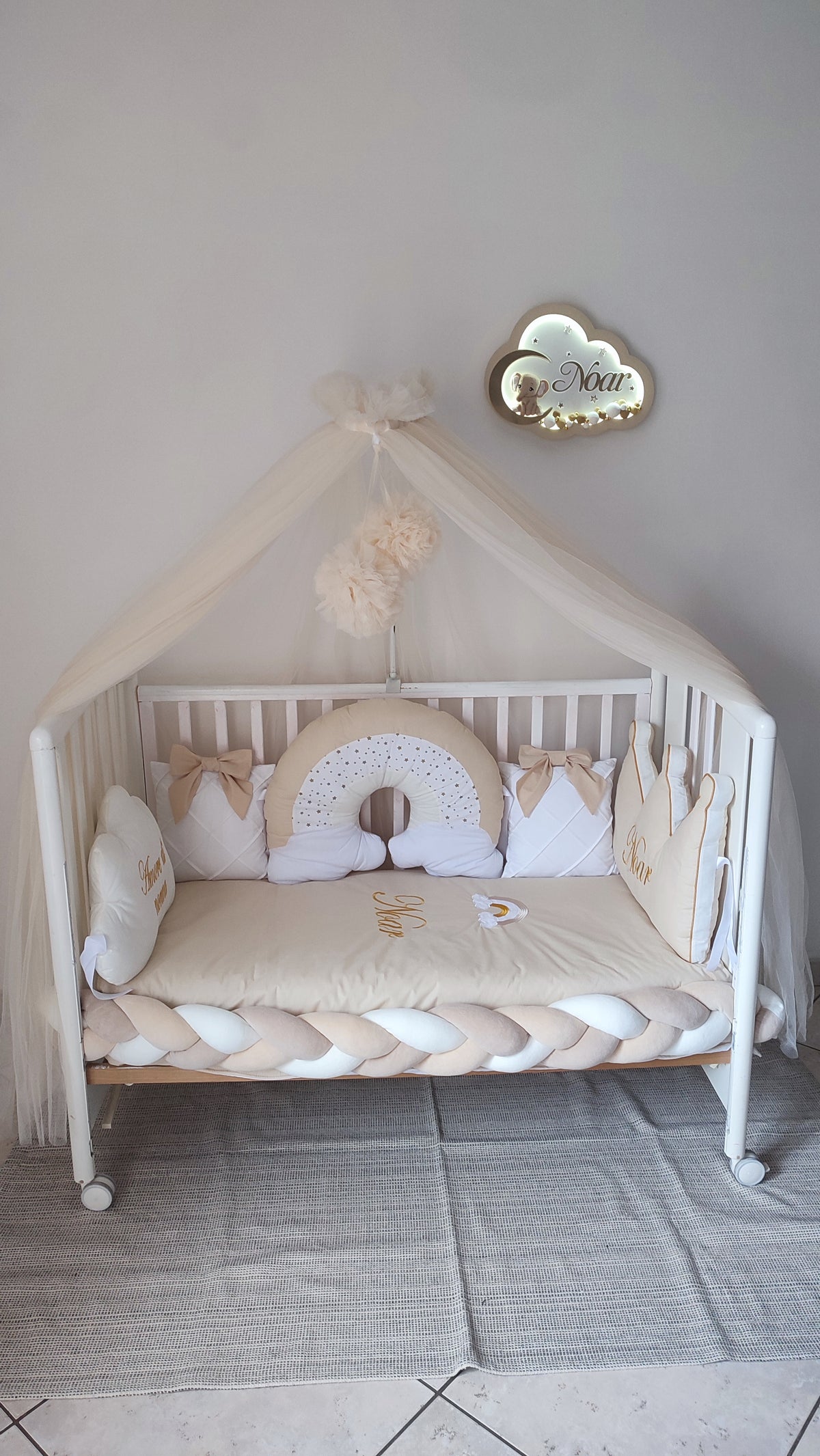 Paracolpi lettino neonato a treccia beige e bianco con cuscini arcobaleno, corone con fiocco e nome ricamato