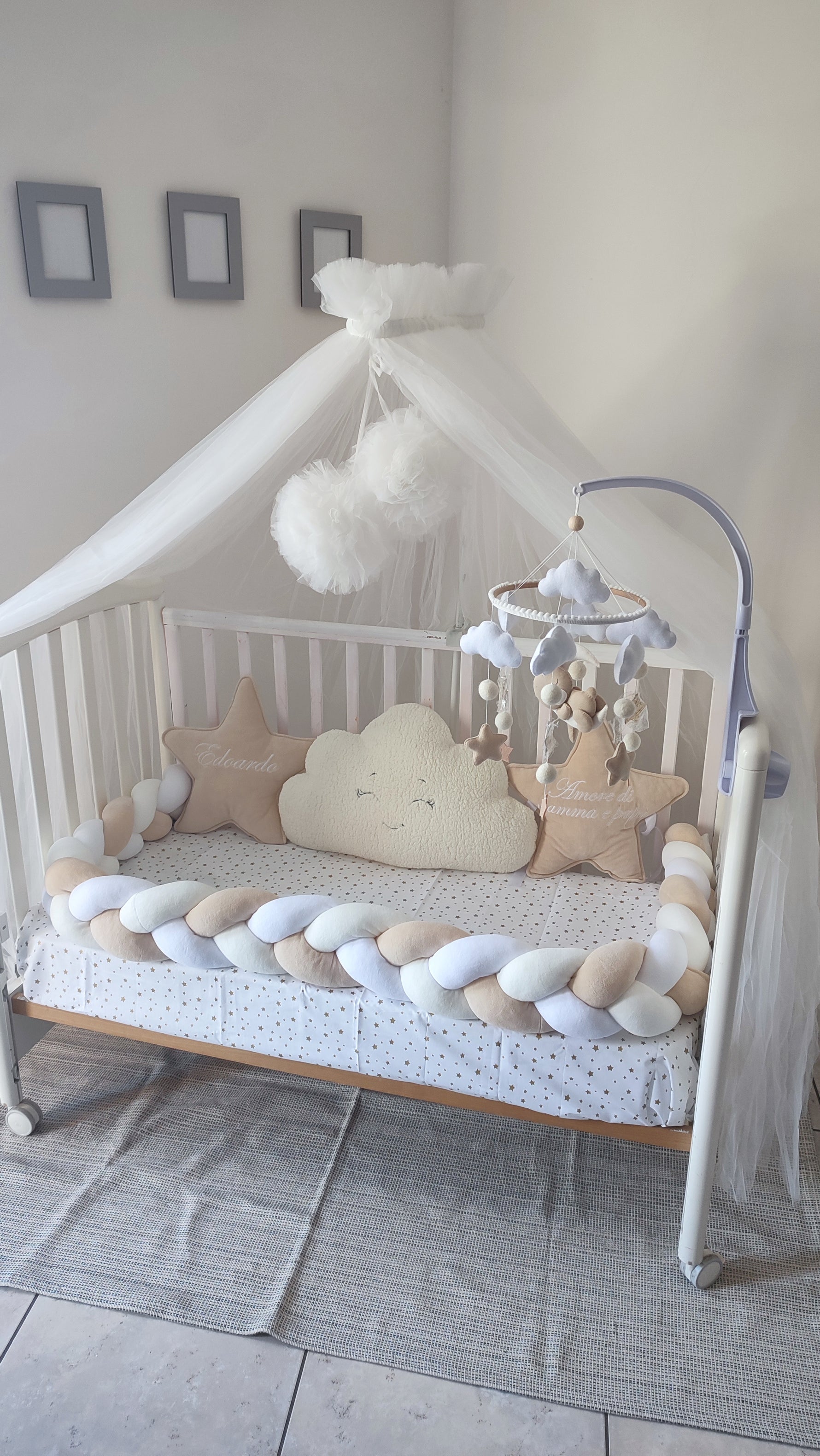 Paracolpi per lettino a treccia nei colori bianco e beige, completo di cuscini a forma di nuvola e stella personalizzati per neonato.