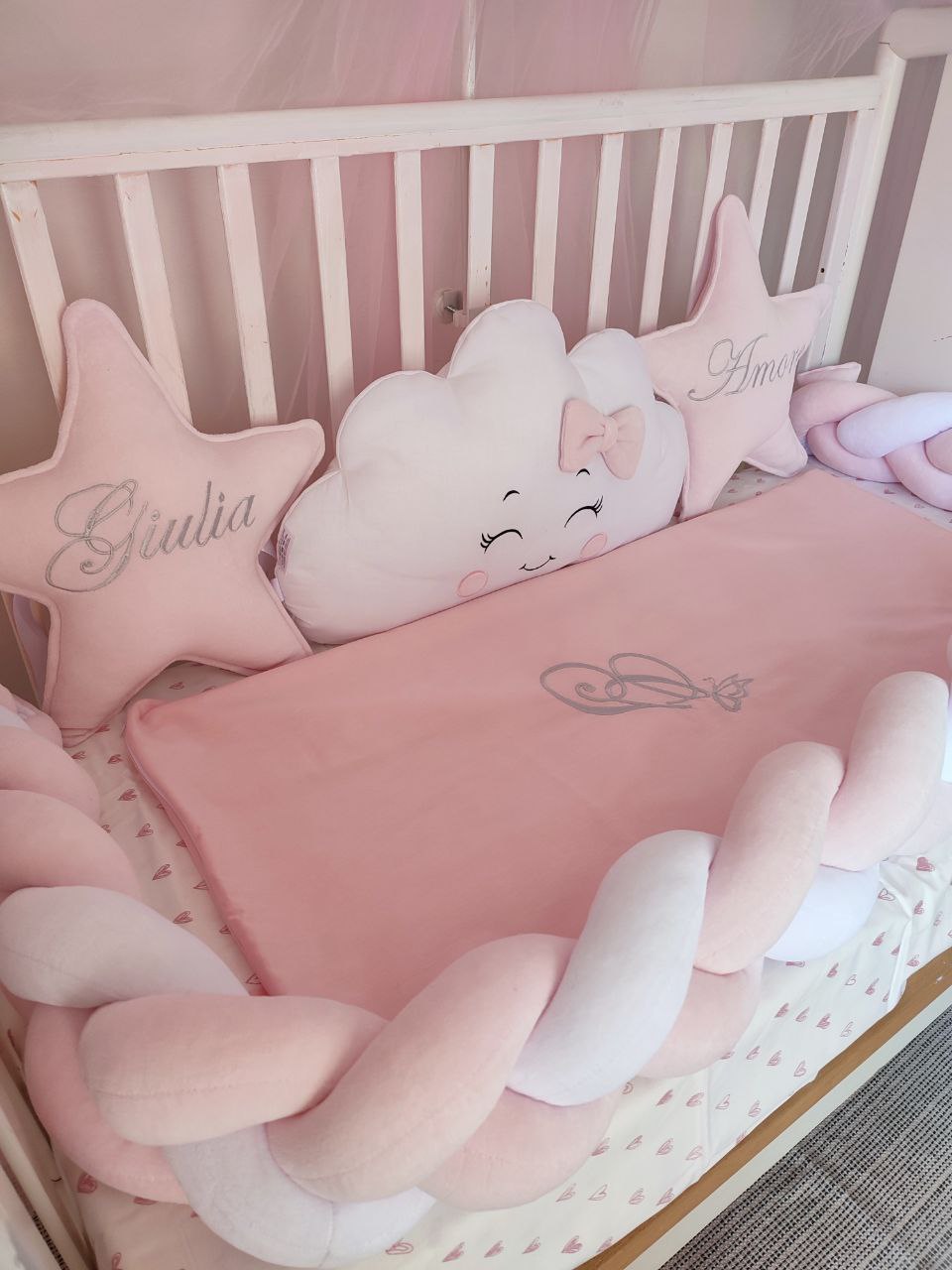 Paracolpi a treccia rosa e bianco con cuscino stella personalizzato, cuscino nuvola ricamato e copertina coordinata.