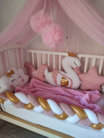 Lettino neonato con paracolpi intrecciato bianco e rosa, coperta a maglia e cuscini decorativi per cameretta bimba.