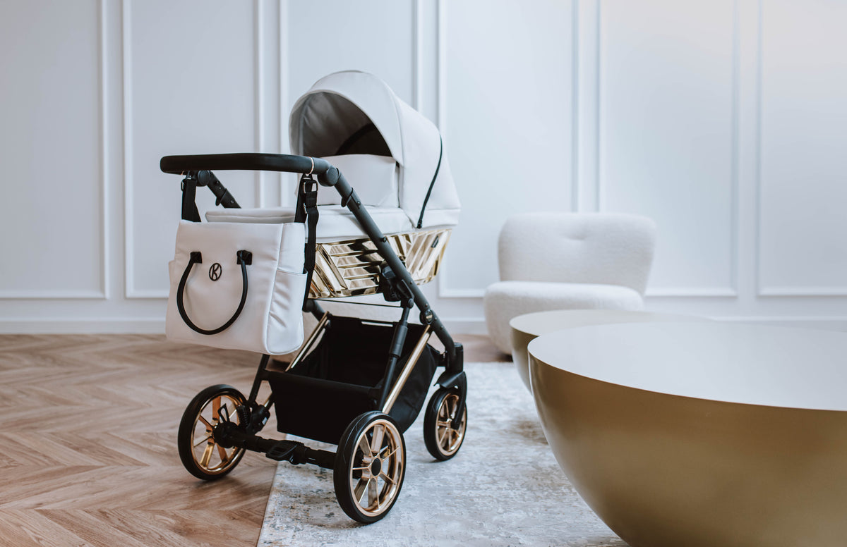 Kunert Ivento Glam navicella bianco perla telaio dorato e borsa fasciatoio abbinata, ruote cerchi oro, ambiente elegante