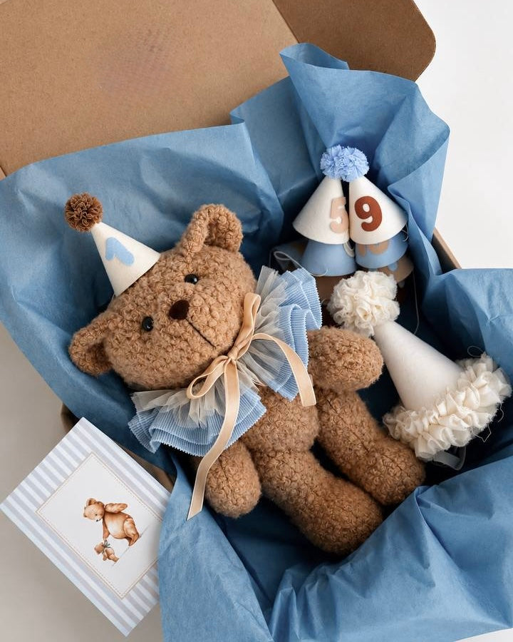 Peluche orso con colletto in tulle azzurro, cappellini numerati e biglietto abbinato